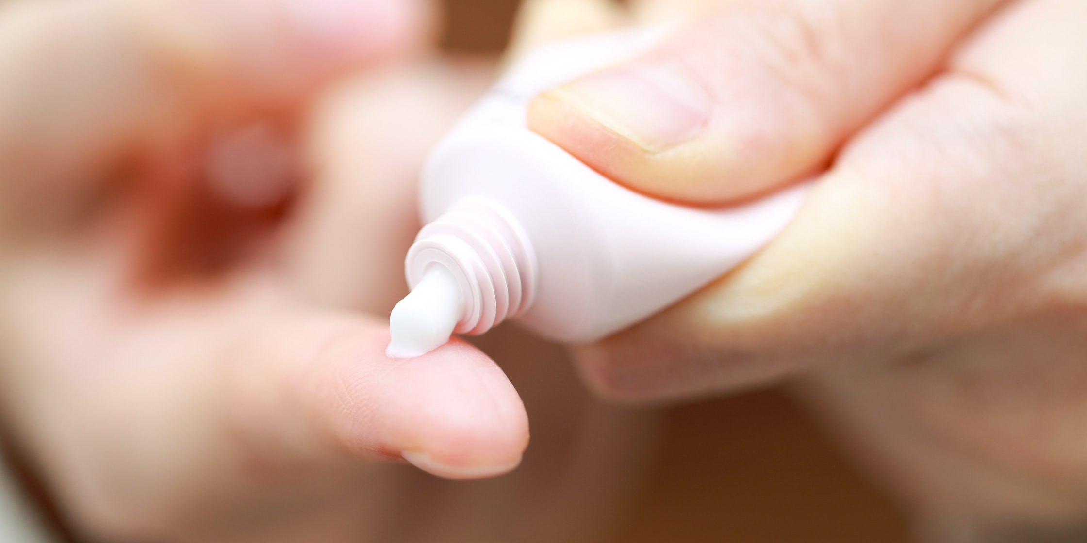 塗り薬を指に絞り出す手元のイメージ